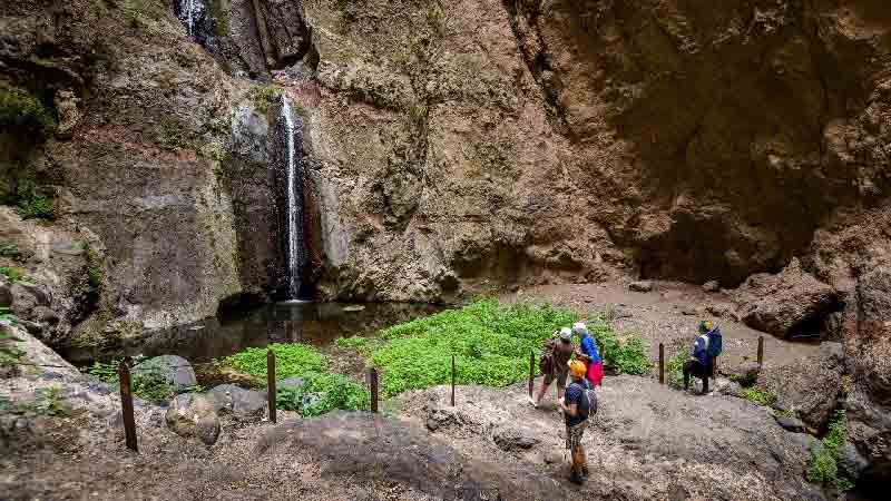 Barranco del Infierno Hike – Waterfall and canyon trail in Tenerife Group of hikers wearing helmets at Barranco del Infierno waterfall in Tenerife’s protected gorge