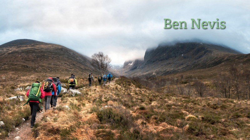 Ben Nevis hiking trail in the Scottish Highlands Hiking group on the Ben Nevis trail in the Scottish Highlands with mountains and clouds in the background.