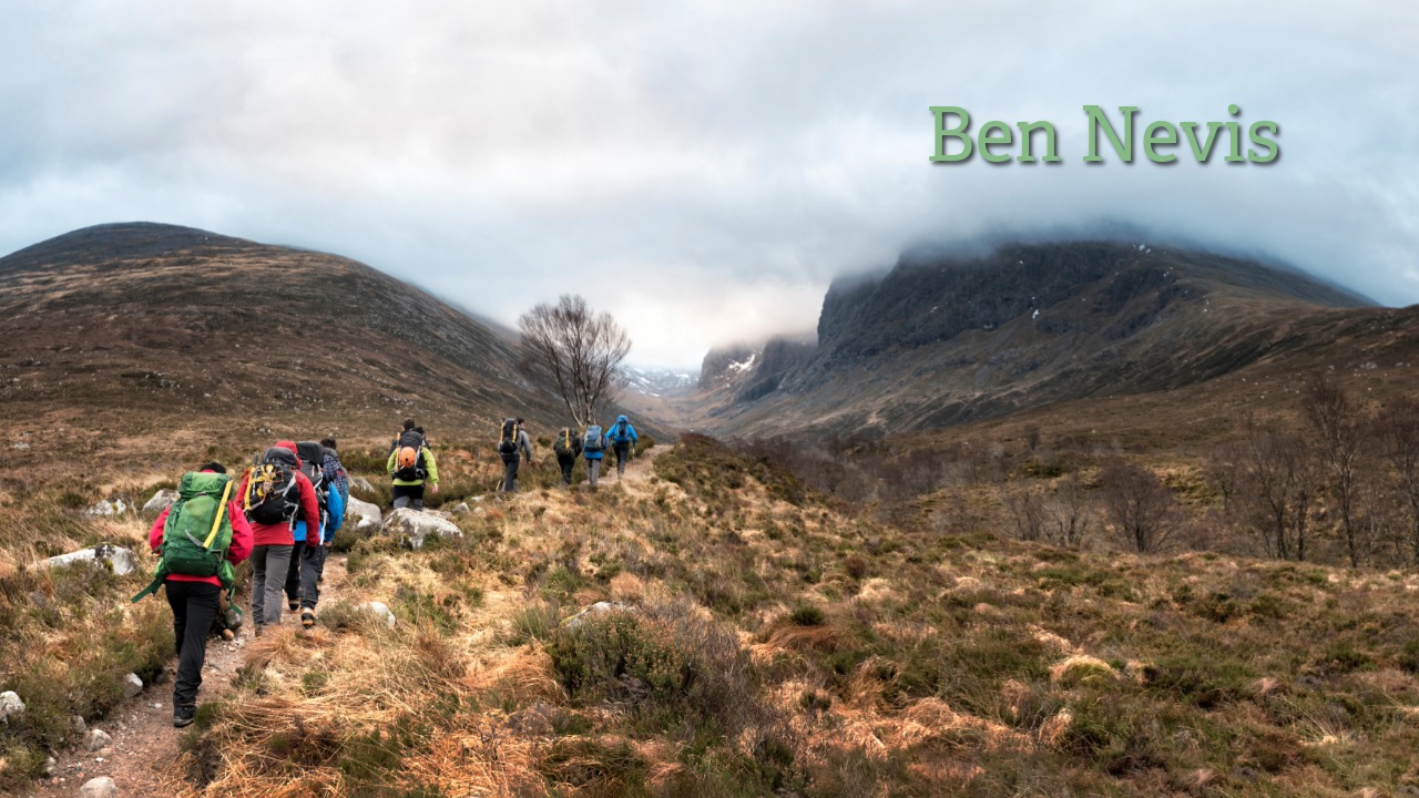 Ben Nevis hiking trail in the Scottish Highlands Hiking group on the Ben Nevis trail in the Scottish Highlands with mountains and clouds in the background.