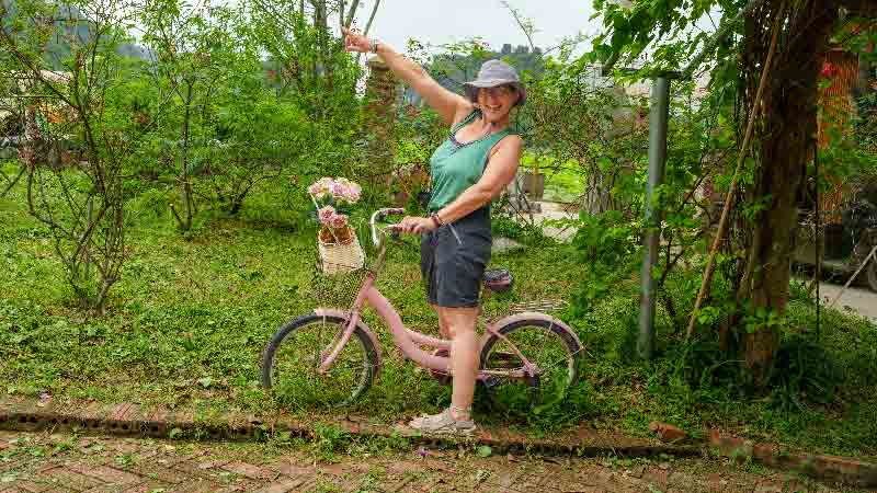 María's Green Adventure - Embracing Sustainable Travel on a Pink Bicycle María riding a pink bicycle surrounded by greenery, promoting sustainable travel and eco-friendly adventures