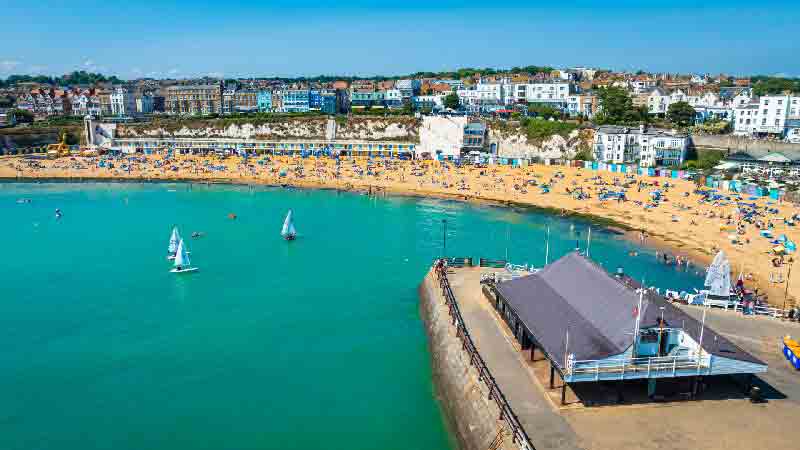 Broadstairs Coastal Walk – Viking Bay beach and harbour view Broadstairs Viking Bay with sandy beach, chalk cliffs and sailing boats on a sunny day in Kent, England
