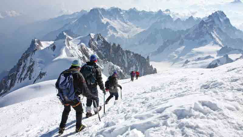 Mont Blanc Expedition 2025 – Climbers descending snowy ridge with the French Alps in the background Group of climbers equipped with mountaineering gear descending Mont Blanc with panoramic views of the French Alps.